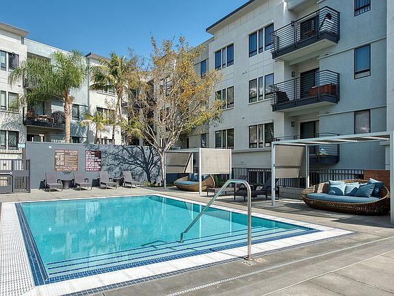 Swimming pool with sundeck cabanas and lounge seating.