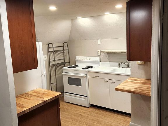Full size range, fridge, and 1940s-era ceramic top sink for accent.