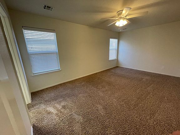 Large master bedroom with ceiling fan and en suite bath with walk-in closet