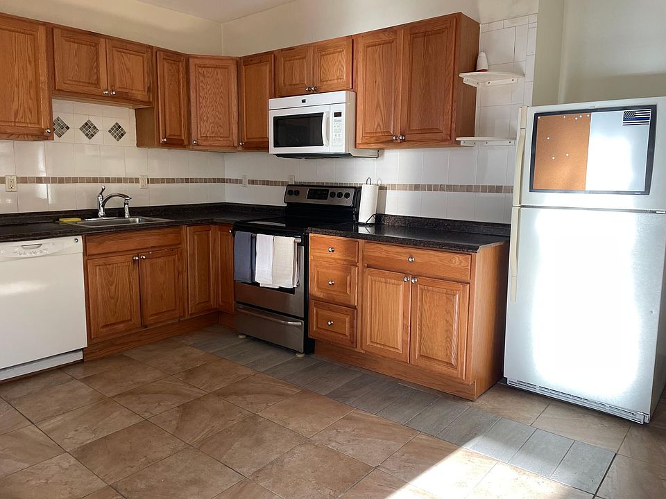 Kitchen - includes dishwasher, electric range, flat top cook surface, large refrigerator, microwave, ceiling fan, door to deck in rear. 13 x 14 sq.ft.