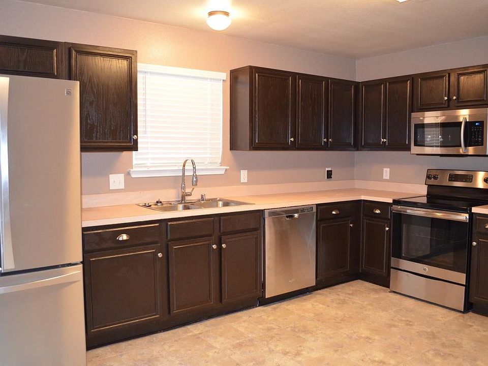 Kitchen with dark wood cabinets, all stainless steel applian