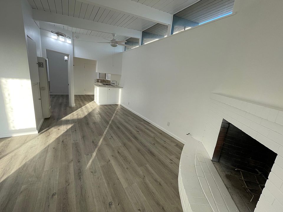 View of kitchen and dining space from living room. Extra windows on side wall fill the apartment with cheery, natural light!