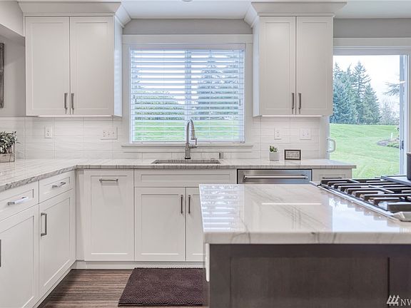 Custom built cabinets with slow close doors/drawers and low profile under cabinet lighting.    The beautiful veined countertops complement the luxury kitchens style.