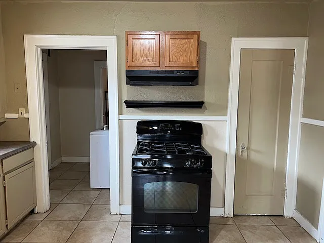 Kitchen with gas stove and vent hood