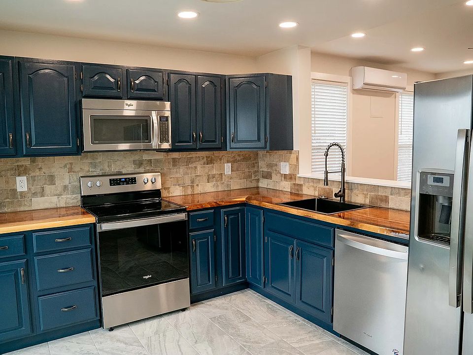 Kitchen with air fryer range, dishwasher, microwave, garbage disposal, refrigerator, dimmable lighting.