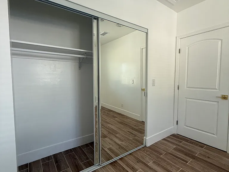 Sliding door closet with large mirrors.