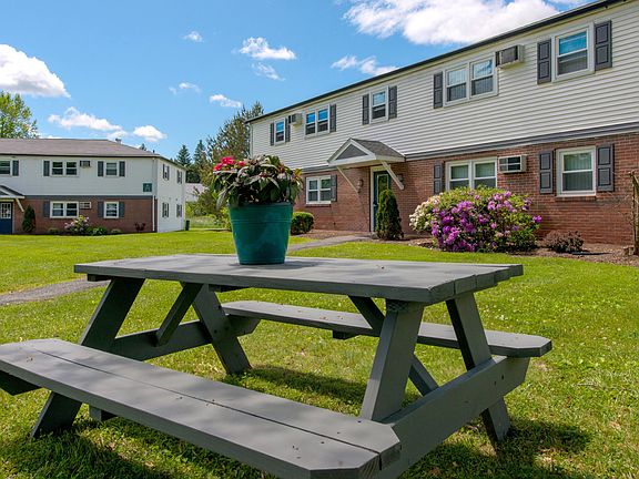 Elevate your outdoor gatherings at one of our inviting picnic tables, where blue skies and lush landscapes set the stage for memorable moments with friends.