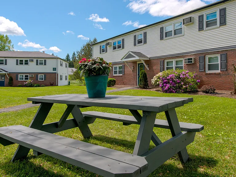 Elevate your outdoor gatherings at one of our inviting picnic tables, where blue skies and lush landscapes set the stage for memorable moments with friends.