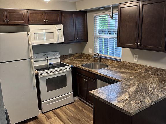 Kitchen with new dishwasher and microwave.