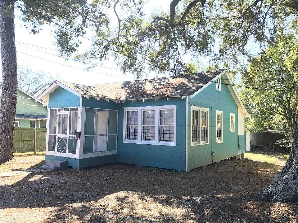 Front of house with screened porch and shade trees