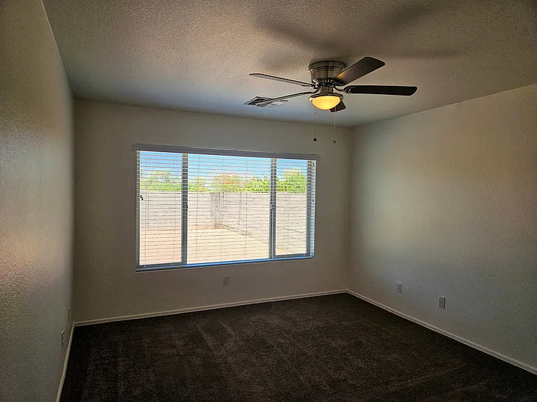 Primary bedroom with ceiling fan and lovely views.