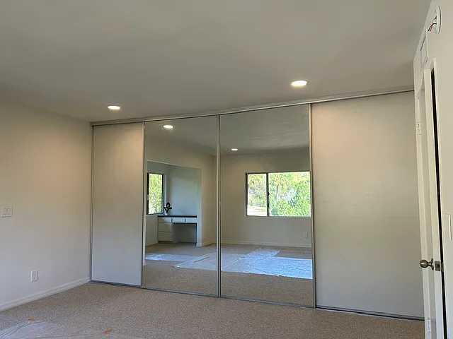 Wall-to-wall custom closet behind dual doors.