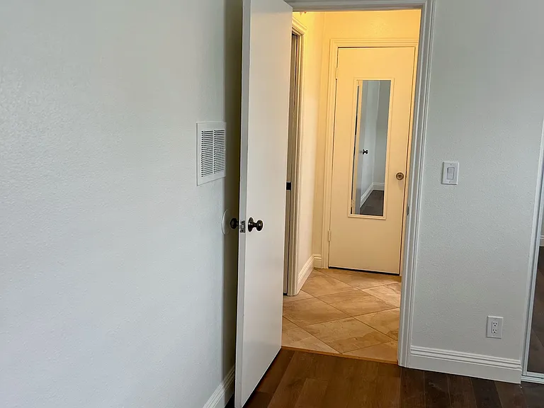 photo from bedroom looking in hallway, hall closet with mirror and lots of storage