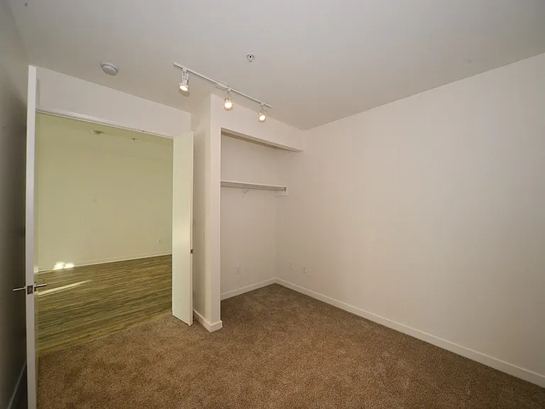 Carpeted bedroom with lots of room to hang clothing at 12th Street Lofts in National City, California.