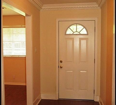 Entry with fluted crown molding and laminate wood floors. Home freshly repainted recently. Light fixtures updated and recessed cans throughout.