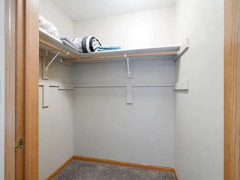 Keep your wardrobe organized with a spacious walk-in closet designed for convenience.