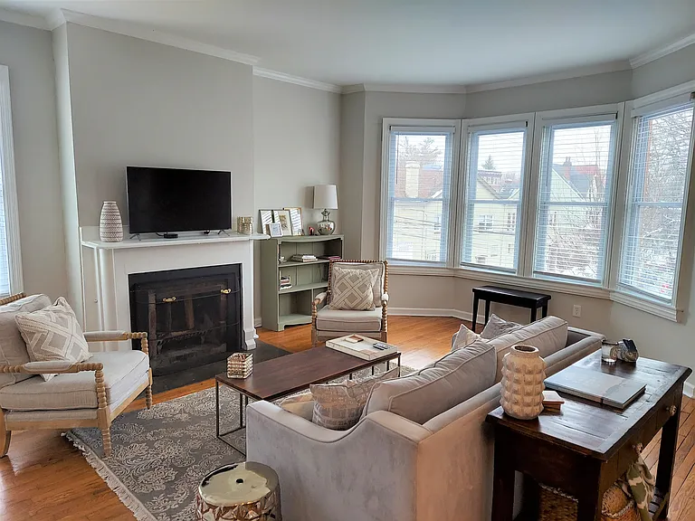 Living Room is filled w/ beautiful natural light, high ceilings, hardwood floors.