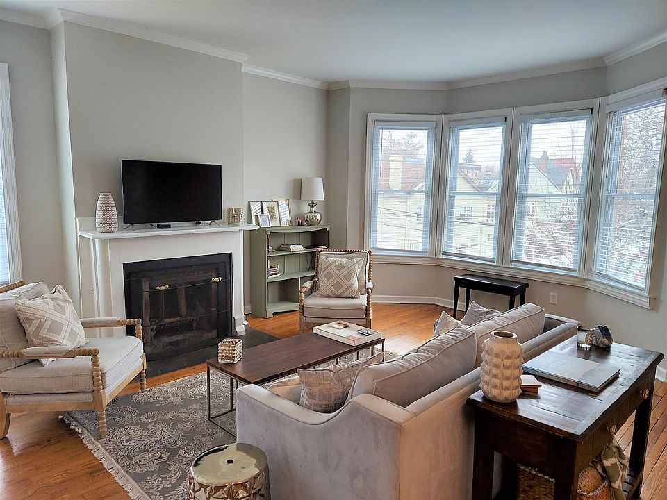 Living Room is filled w/ beautiful natural light, high ceilings, hardwood floors.