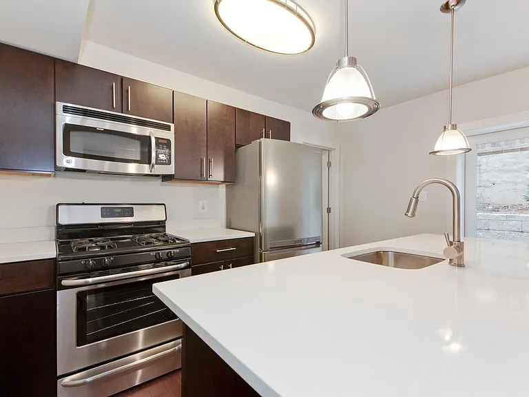 Kitchen with dishwasher, gas stove, microwave, garbage disposal, and modern fridge.