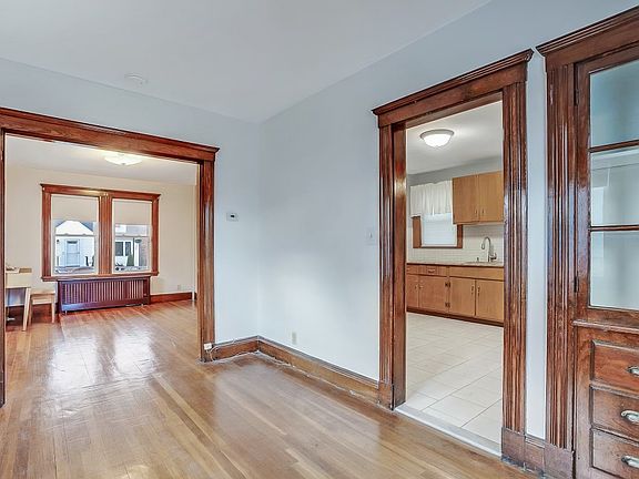 A sunny dining room opens to an even sunnier living room for seamless, light-filled living. The large kitchen features timeless built-in china cabinets and a proper pantry_style and storage in one. Warm, open, and ready for gatherings.