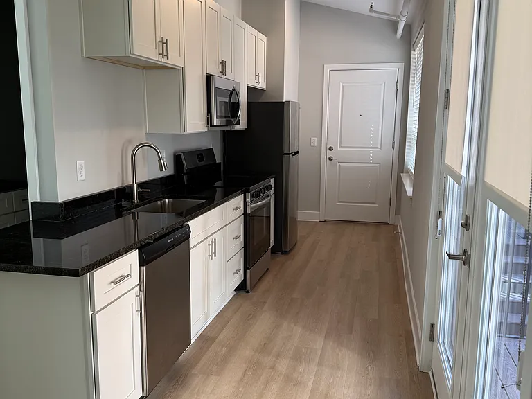 Galley kitchen with range, dishwasher, microwave, and refrigerator/ice maker