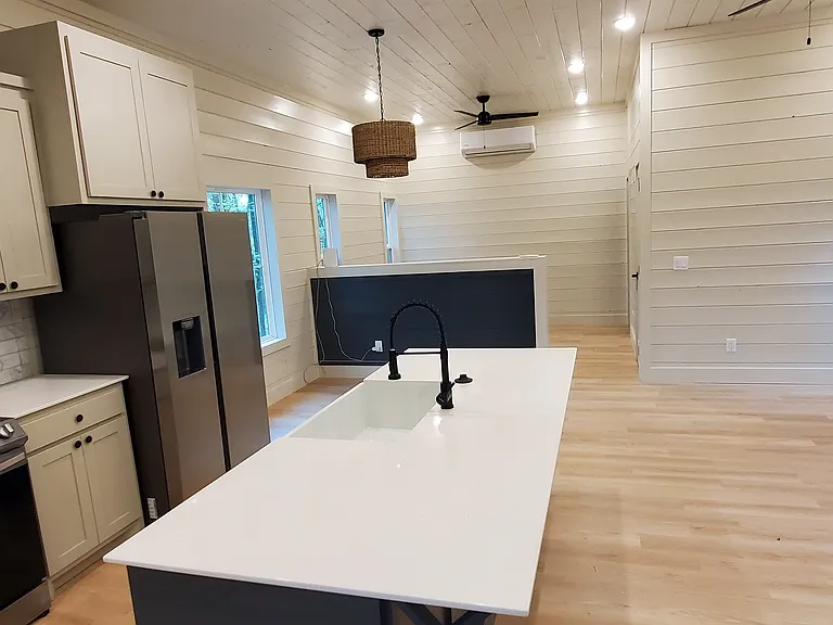 Kitchen island d with granite overhang for bar seating.