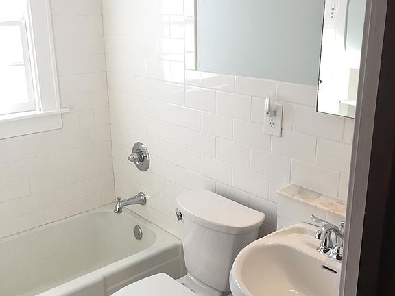 Freshly tiled bathroom. New sink, toilet, subway tile and marble floor.