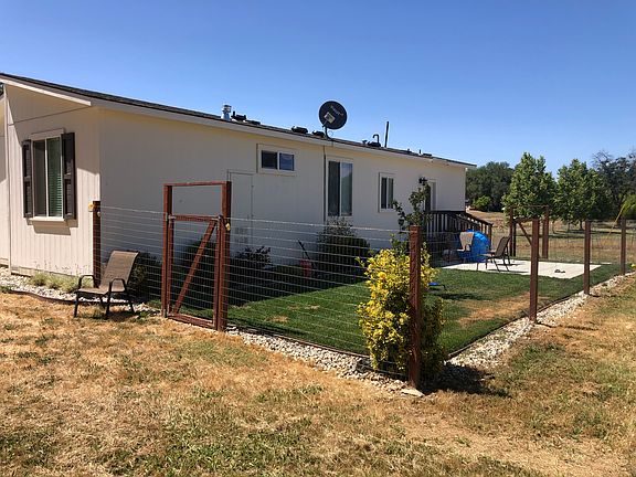 Rear view of house showing fenced yard. There are two gates - one at each end of the yard.