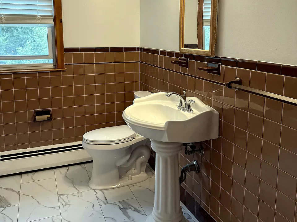 Full bath with a brand new marble-look tile floor, pedestal sink, and its own window for real daylight. Water is triple-purified.