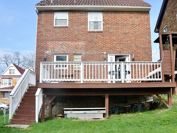 Large 20x13' back deck with built-in seating and a fire pit in the back yard.