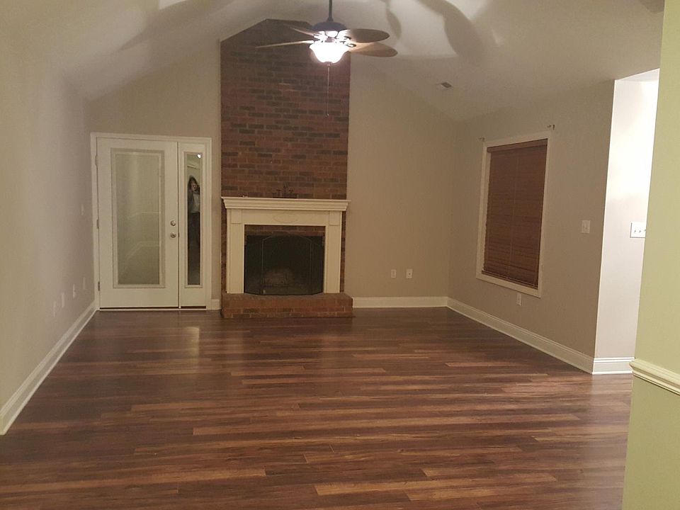 Living room with wood burning fireplace and vaulted ceiling