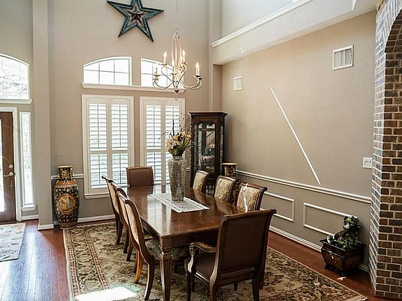 Dramatic two story dining room with custom molding and a wall of windows to let in the natural light.