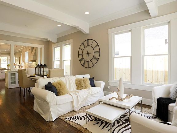 This living room features high, beamed ceilings, beautiful moldings and flows beautifully to the for