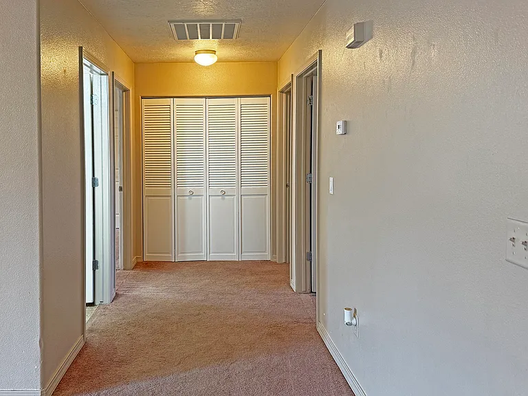 Hallway with Laundry Area at the far end, with doors to 2nd and 3rd Bedroom oin right, and doors to 2nd bath and Msster on the left