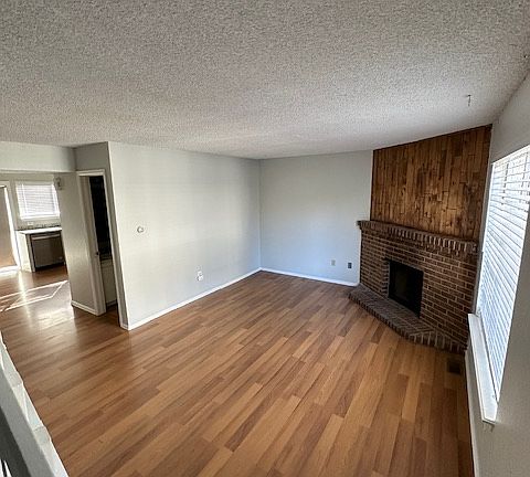 Living room with laminate floors, fireplace.