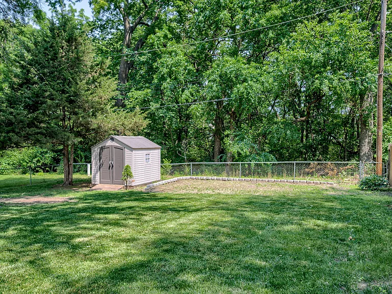 Looking back from the middle of the yard shows the consistent shading provided by the mature trees, leveled wall area provides excellent seating / hangout area near back treed/wooded area