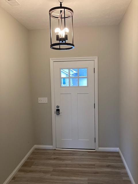 Open Hallway with Modern Light Fixture and Combination Door Lock