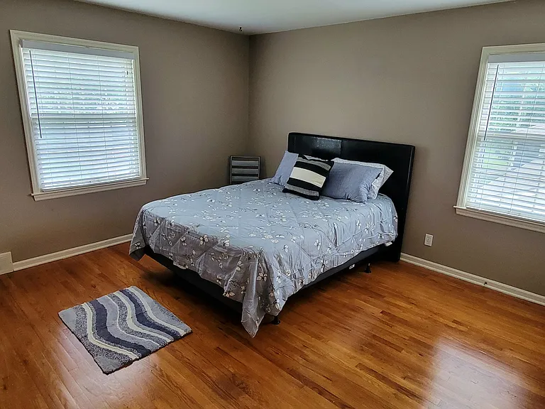 1st bedroom furnished with queen size bed, hardwood floors, new bedding and rug, double closet space. Need more storage? There's plenty of room for larger items to be stored in the downstairs individual basement area.