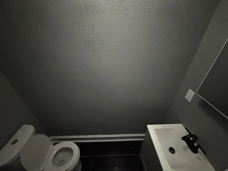 Compact half bath with toilet and vanity sink, offering a convenient setup for guests and everyday use.