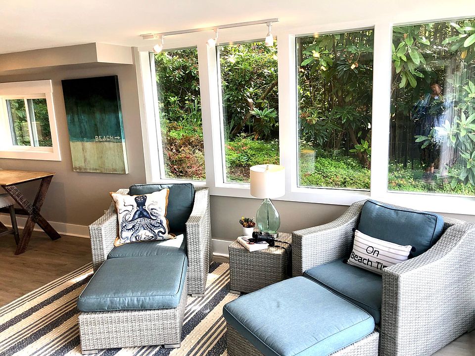 South facing windows flanked by rhododendrons.