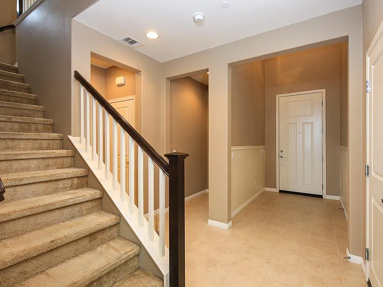 Left to Right: Stairs, Downstairs Half Bathroom, Downstairs Bedroom w/ En Suite Bathroom, Front Door, Garage Door Entry