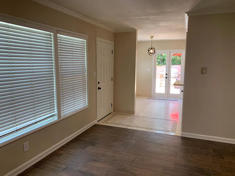 View from living room to dining room and kitchen to french doors and outdoor patio.