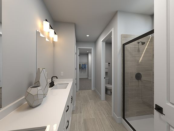 The primary bathroom offers dual vanity sinks and a walk-in shower.