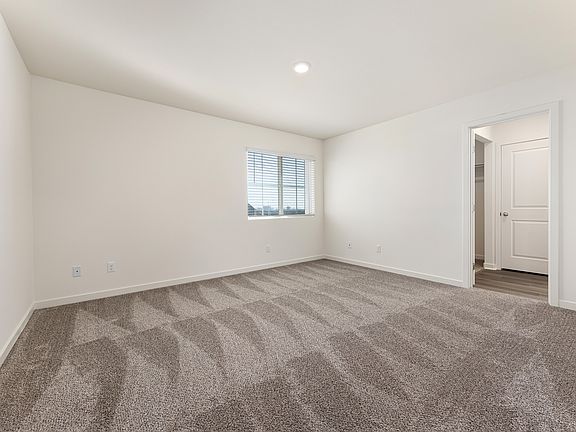 The master bedroom has carpet and a large window.