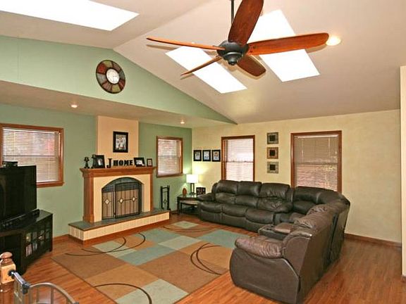 Gorgeous family room highlights the interesting ceiling lines, sky lights, gas fireplace and ceiling fan.  A closed off laundry and dryer area is to the right of the room should one prefer a main floor laundry.There is an open stairway to the basement just to the left. Sliding doors open to a 12x16 brick patio and fenced backyard. 
