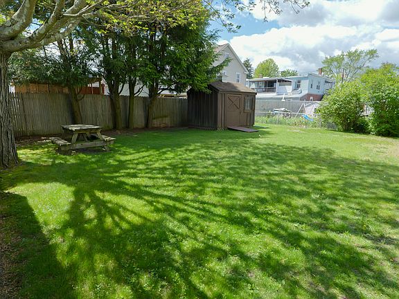 Fenced in back yard with shed and picnic table