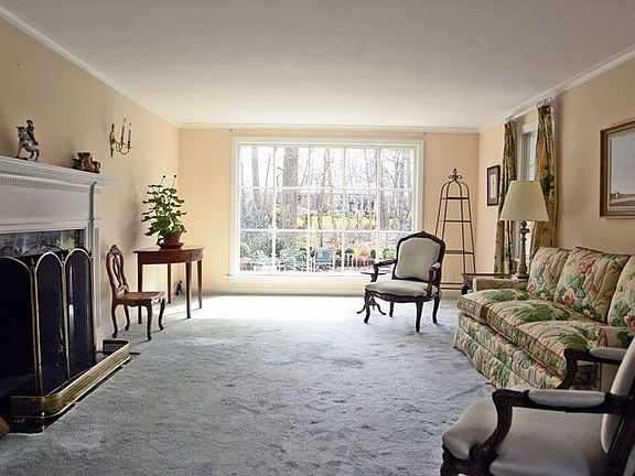 formal living room w/ fireplace , floor to ceiling window overlooking gardens