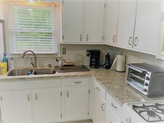 Kitchen has new granite counters and white cabinets