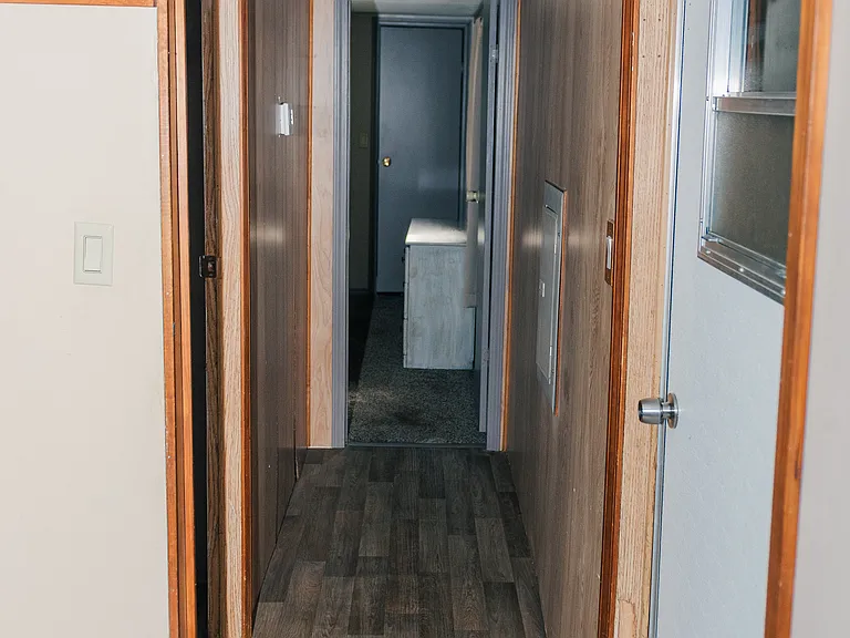 Hallway from laundry/pantry towards second bedroom and Master bedroom. Door on the right leads to external bonus room