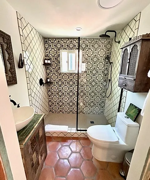 Casita bathroom with heated saltillo floors and hand-painted Talavera tiles in the walk-in rain shower.
